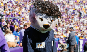 LSU’s Mike the Tiger stalks referee while dressed as Michael Myers, appears to be steered away by staffer