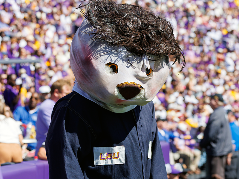 LSU’s Mike the Tiger stalks referee while dressed as Michael Myers, appears to be steered away by staffer